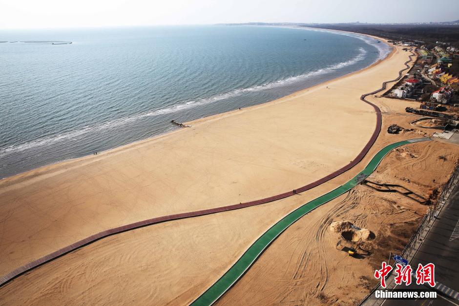3月13日，秦皇島萬米臨海沙灘木棧道。據(jù)了解，該木棧道全長(zhǎng)約4200米，與北戴河區(qū)原有的7500米木棧道對(duì)接后全線總長(zhǎng)度1.17萬米，整個(gè)木棧道東起秦皇島體育基地游船碼頭，西至北戴河濕地公園，呈波浪形蜿蜒10.4公里海岸線。 中新社發(fā) 曹建雄 攝 CNSPHOTO