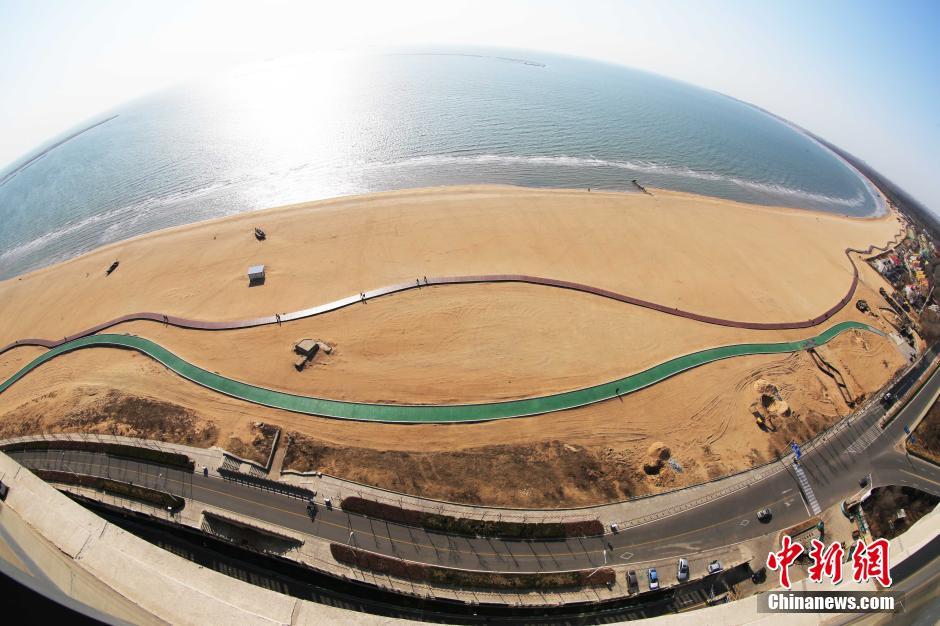 3月13日，秦皇島萬米臨海沙灘木棧道。據(jù)了解，該木棧道全長(zhǎng)約4200米，與北戴河區(qū)原有的7500米木棧道對(duì)接后全線總長(zhǎng)度1.17萬米，整個(gè)木棧道東起秦皇島體育基地游船碼頭，西至北戴河濕地公園，呈波浪形蜿蜒10.4公里海岸線。 中新社發(fā) 曹建雄 攝 CNSPHOTO